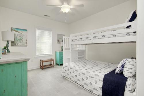 a bedroom with a white bunk bed and a kitchen at Grace by the Sea in Myrtle Beach