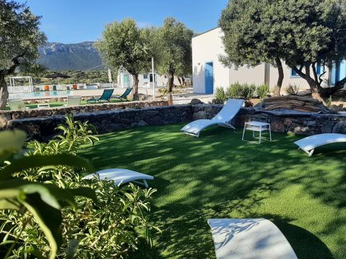 a yard with lounge chairs and a lawn at Borgo Rurale Cares in Dorgali