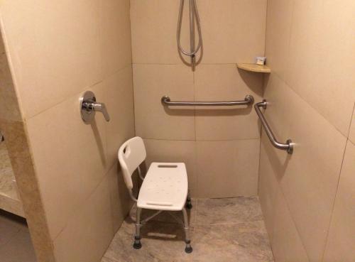 a bathroom with a toilet with a chair in it at Holiday Inn Express Puerto Vallarta by IHG in Puerto Vallarta