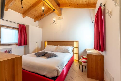 a bedroom with a large bed with red curtains at For Rest in Madesimo