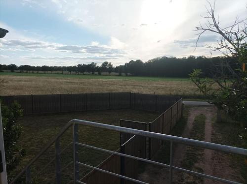 a fenced in field with a fence and a field at Studio en pleine campagne avec jardin privatif in Bournand