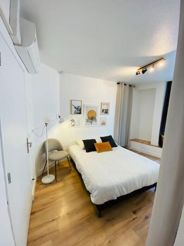 a bedroom with a white bed and a chair at Les studios de Morgane hyper centre in Valence