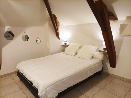 1 dormitorio con 1 cama con sábanas blancas y 2 lámparas en Studio en pleine campagne avec jardin privatif, en Bournand