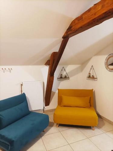 a living room with a blue and yellow couch at Studio en pleine campagne avec jardin privatif in Bournand