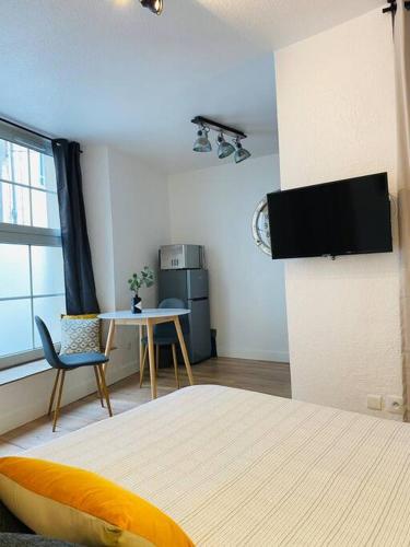a bedroom with a bed and a table and a tv at Les studios de Morgane hyper centre in Valence