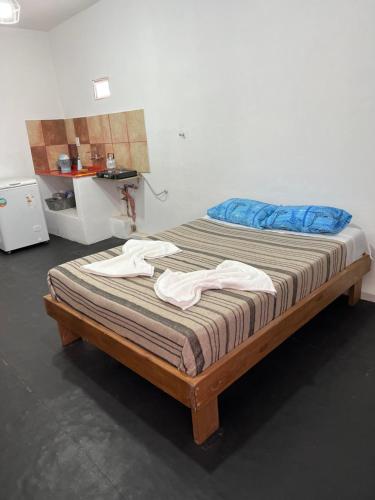 Una cama en una habitación con ropa. en Departamento Sarmiento 1, en San Luis