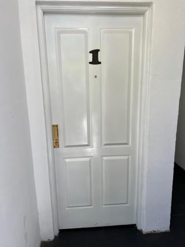 Una puerta blanca con un mango negro en una habitación en Departamento Sarmiento 1, en San Luis