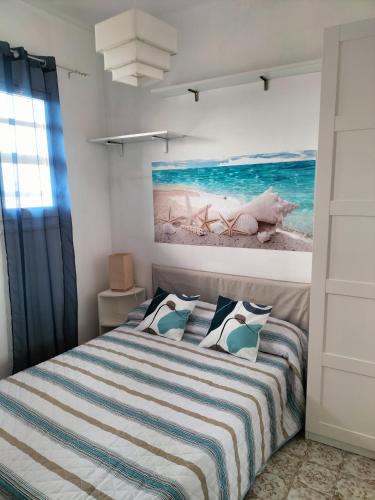 a bedroom with a bed with a painting on the wall at Casa Mary in Marotta