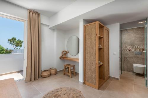 ein Bad mit einer Dusche, einem WC und einem Spiegel in der Unterkunft Absolute Kiotari Resort in Asklipiḯon