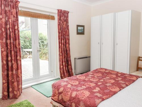 une chambre avec un lit et une grande fenêtre dans l'établissement Gwylan Apartment, à Tenby