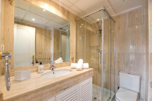 マルベーリャにあるLa Terraza Apartment Elviria Marbellaのバスルーム(洗面台、ガラス張りのシャワー付)