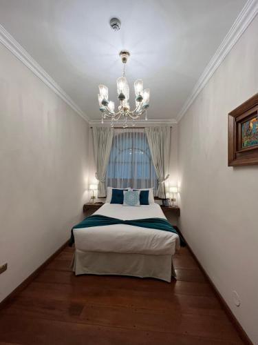 a bedroom with a bed and a chandelier at Dakani Hotel Boutique NEW in Quito