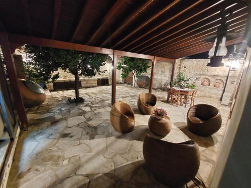 un patio con sillas, una mesa y un árbol en Evanthia's Stone House, en Koilani