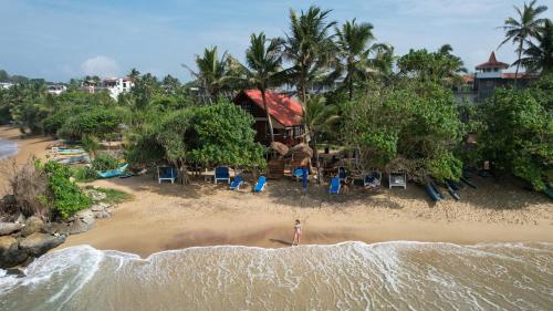 an aerial view of a beach with chairs and buildings at Turtle Bay Beach Resort in Mirissa