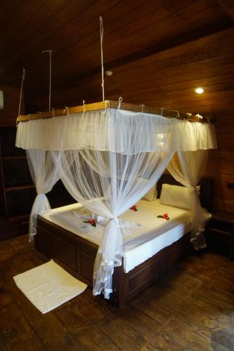 a bedroom with a bed with a canopy at Turtle Bay Beach Resort in Mirissa