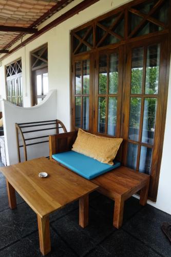 a wooden bench with a pillow on a table at Turtle Bay Beach Resort in Mirissa