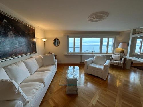 Lakeside Apartments Rorschach - easy self check-in في رورشاخ: غرفة معيشة مع أريكة بيضاء وطاولة