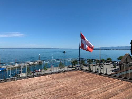 a flag on a boardwalk next to the water at Lakeside Apartments Rorschach - easy self check-in in Rorschach