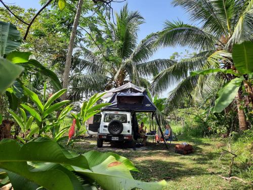 a jeep with a tent on the back in a forest at La Muñequita Lodge 2 - culture & nature experience in Palmar Sur