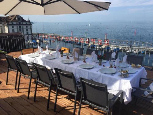 a table with a white table cloth and chairs and a pier at Lakeside Apartments Rorschach - easy self check-in in Rorschach