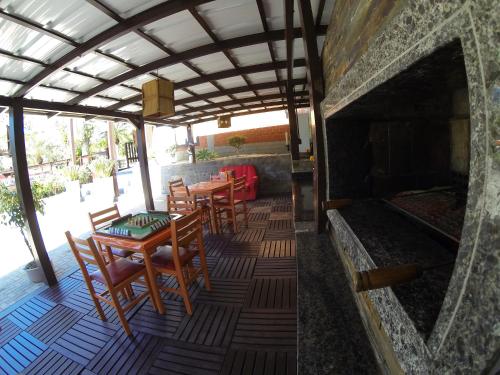 a patio with a table and chairs and a fireplace at Pousada Magnus in Balneário Camboriú