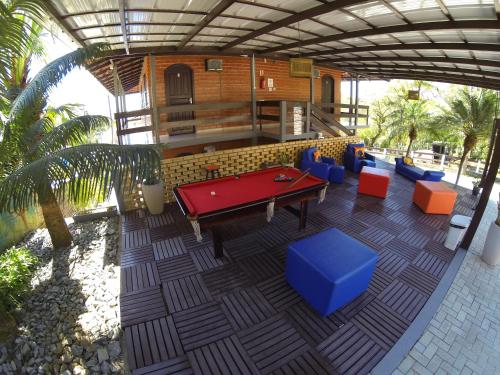 a patio with a pool table and some blue chairs at Pousada Magnus in Balneário Camboriú
