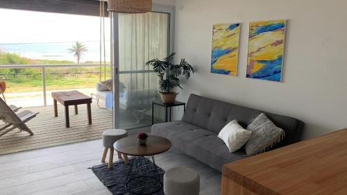 sala de estar con sofá y vistas al océano en Altamar Casas de Playa, en La Paloma