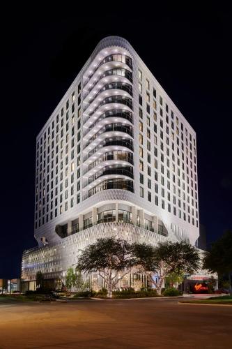 a large white building at night at Virgin Hotels Dallas in Dallas