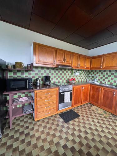 a kitchen with wooden cabinets and a stove top oven at PK 35 in Apomaoro