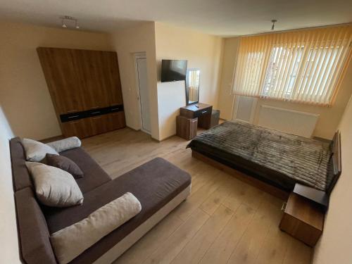 een woonkamer met een bank en een koelkast bij Villa Stoyanovata Kashta in Samokov