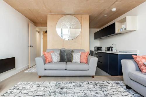 a living room with a couch and a kitchen at Two Bedrooms Exquisite En-Suite Apartment Deansgate in Manchester
