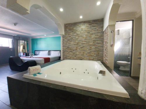a large bath tub in a room with a bed at Real La Viga Motel in Mexico City