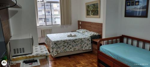 ein Schlafzimmer mit 2 Betten und einem TV. in der Unterkunft Temporada Copacabana Salu 1 in Rio de Janeiro