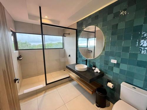 a bathroom with a sink and a mirror at Marala Hotel in Esterillos