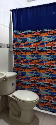 baño con aseo y cortina de ducha azul en Apartaestudio, en Santa Marta