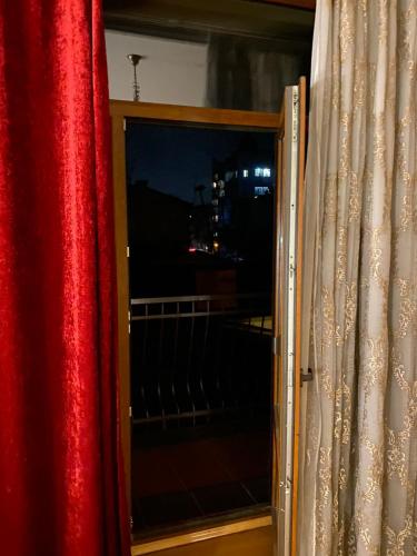 a sliding glass door with a red curtain at Fontush Boutique Hotel in Ivano-Frankivsʼk