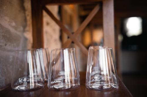 four empty glasses sitting on a wooden table at Hotel Hort De Fortunyo in Arnés