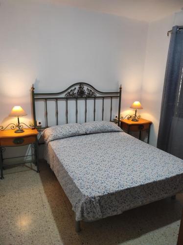 a bedroom with a bed with two lamps on two tables at Apartamentos Can bruguera 3 in Mataró