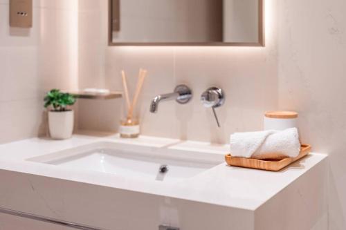 a white bathroom with a sink and a mirror at prime retreats - beach vista Emaar in Dubai