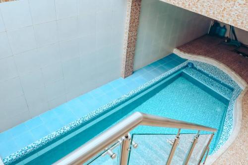 una piscina en una habitación con azulejos azules en Hermosa Casa familiar, piscina, 5 habitaciones, en Cali
