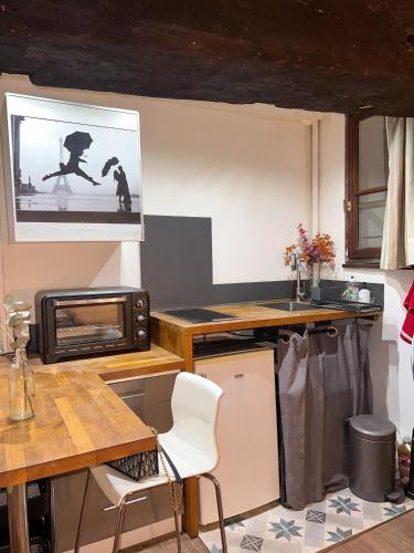 une petite cuisine avec une table et un micro-ondes dans l'établissement Magnifique studio cosy en plein coeur de Paris!, à Paris