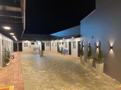 an empty hallway with potted plants in a building at Hotel Goiano in Estreito