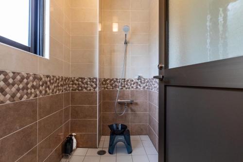baño con ducha, aseo y puerta en Villa Ocean Bridge KOURIJIMA - Vacation STAY 64481v, en Kouri