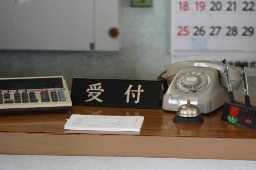 un escritorio con teléfono y calculadora en Hotel Shiosai - Vacation STAY 68131v en Uruma