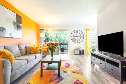 a living room with a couch and a flat screen tv at Shiny oasis with lake view in Sarasota