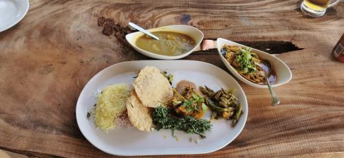 a table with a plate of food and a bowl of soup at Turtle Bay Beach Resort in Mirissa