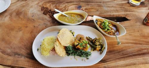 a table with a plate of food and a bowl of soup at Turtle Bay Beach Resort in Mirissa
