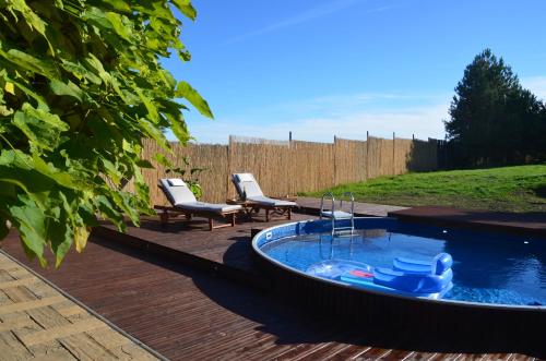 uma piscina com 2 cadeiras e uma banheira de hidromassagem em Holiday, party and relax vila 