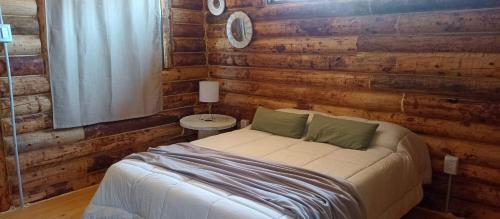 a bedroom with a bed and a wooden wall at WAIKIRI in Potrerillos