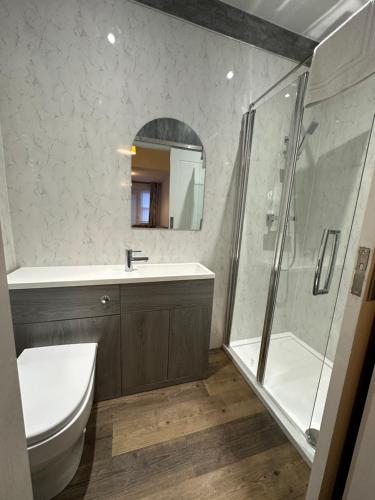 La salle de bains est pourvue d'une douche, de toilettes et d'un lavabo. dans l'établissement Belsay 4 bedroom bungalow with loft conversion, à Horden